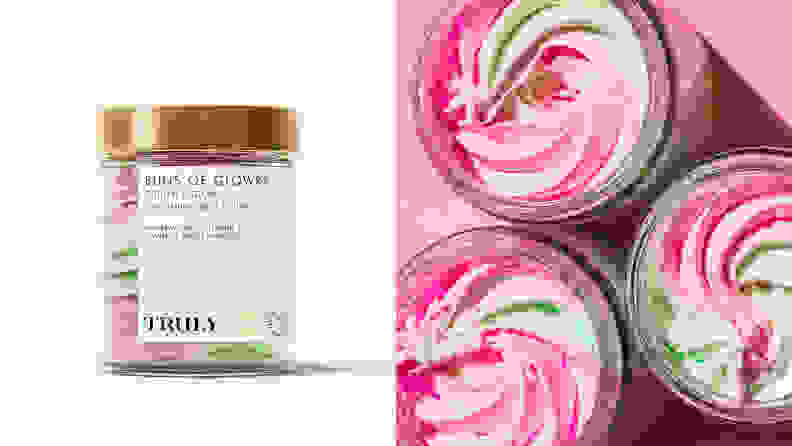 On the left: The clear jar of Truly Beauty Buns of Glowry Smoothing Butt Polish sitting on a light pink background with a pink and green polish inside it. On the right: Three jars of the butt polish are uncapped to reveal a swirl of pink and green exfoliator.