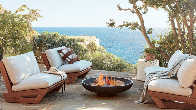 beige outdoor furniture set and fire pit next to the ocean