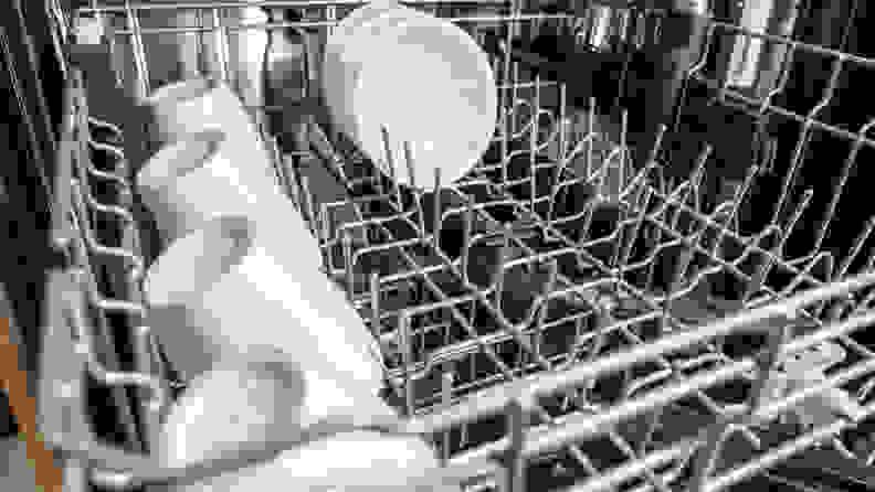 A close-up of the Whirlpool WDT750SAKZ dishwasher's upper rack, with rows of coffee cups stowed away along its left edge.