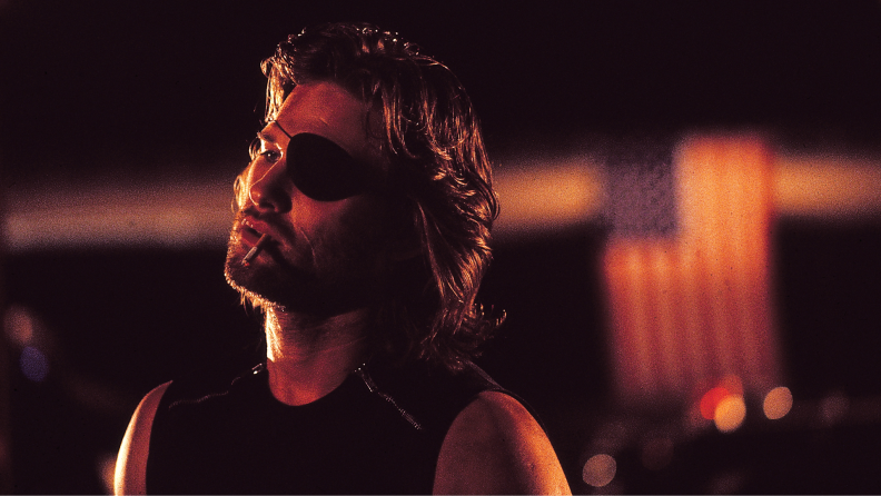 Actor Kurt Russell smokes a cigarette and wears an eyepatch in the John Carpenter film Escape from New York.
