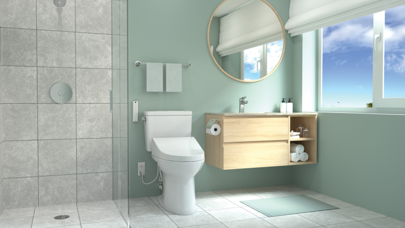 The Toto Drake toilet installed in a bathroom with sea foam green walls.