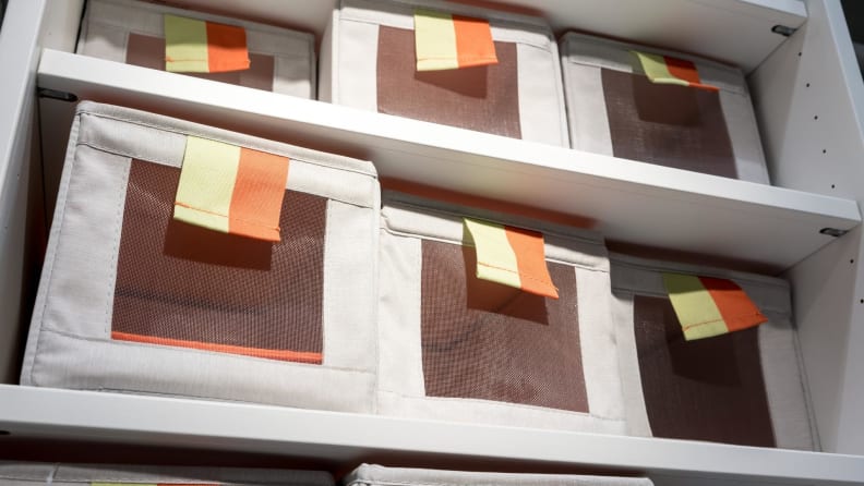 Neatly organized bins in a closet.