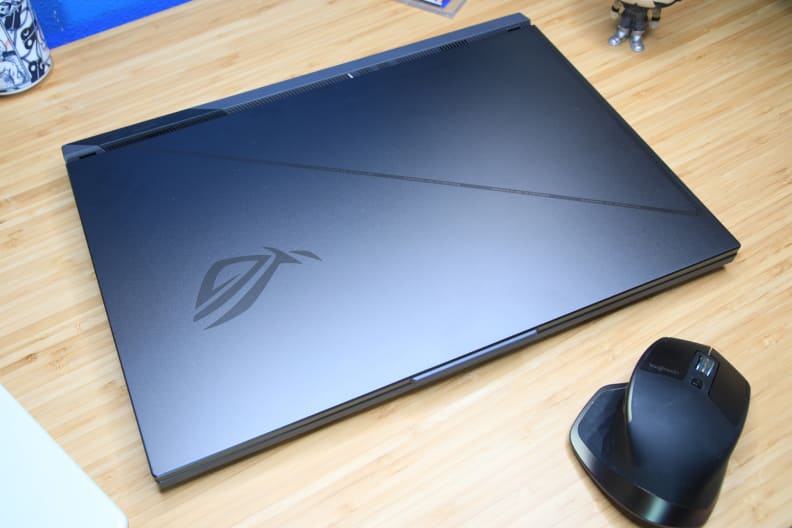 A black laptop on a light brown desk