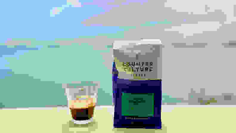 A cup of espresso is next to a bag of Counter Culture Whole Bean coffee.