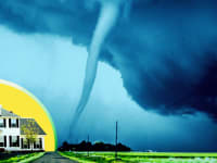 A white-colored home in front of a yellow, circular background opposite a large tornado