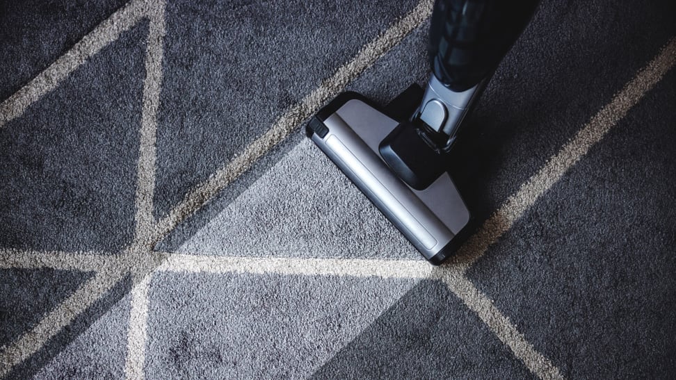 Vacuum cleaning a blue carpet