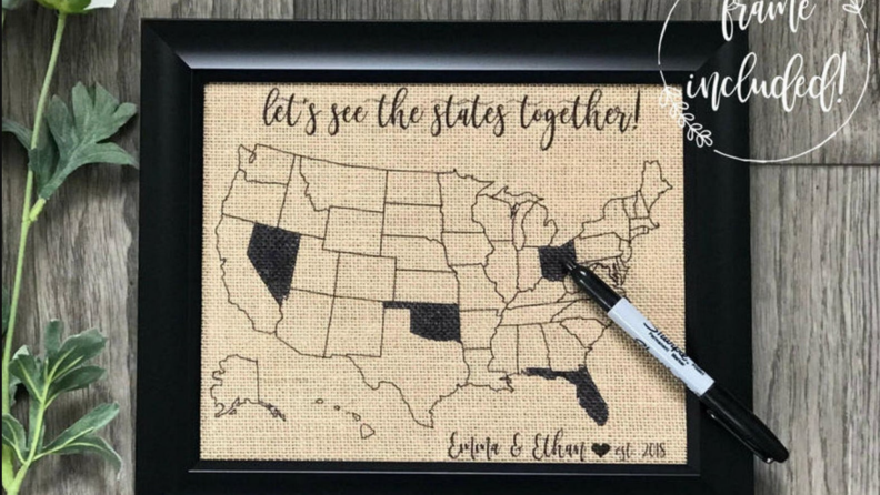 Burlap fill-in map of the United States in black frame with sharpie marker sitting on top.