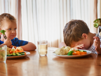 Two boys at a table refusing to eat