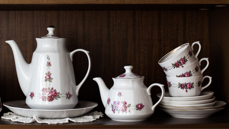 A ceramic tea set sits on a shelf.