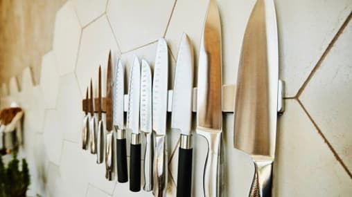 A set of knives hanging on a wall.