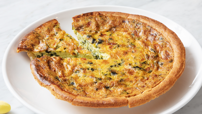 Quiche on a plate with a slice removed