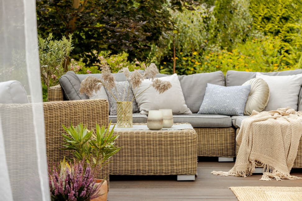 舒适的露台家具与植物，扔枕头和毯子。