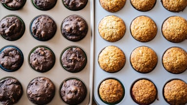 Baked muffins lined up in two different muffin pans.