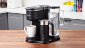 The Keurig K-Café Smart shown on a kitchen counter with a white coffee mug filled with fresh brewed coffee.