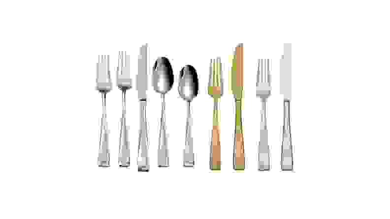 Assorted gold and silver flatware arranged in a row across a white background.