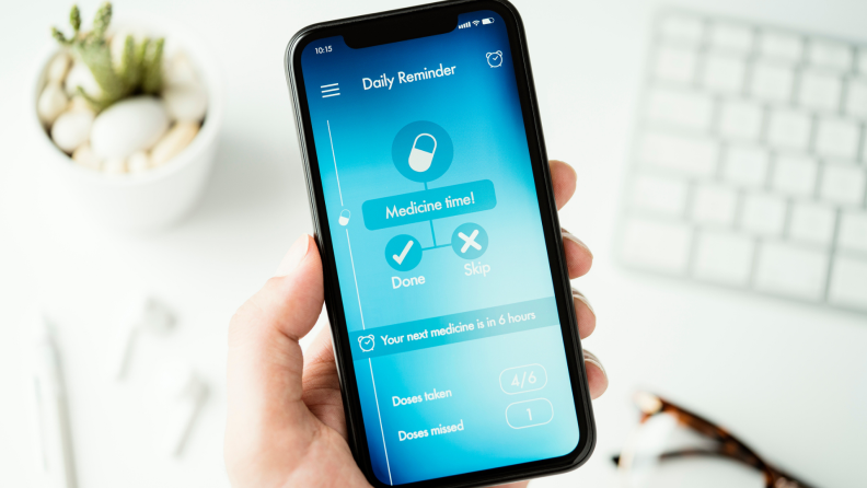 Smartphone with pill reminder on screen.