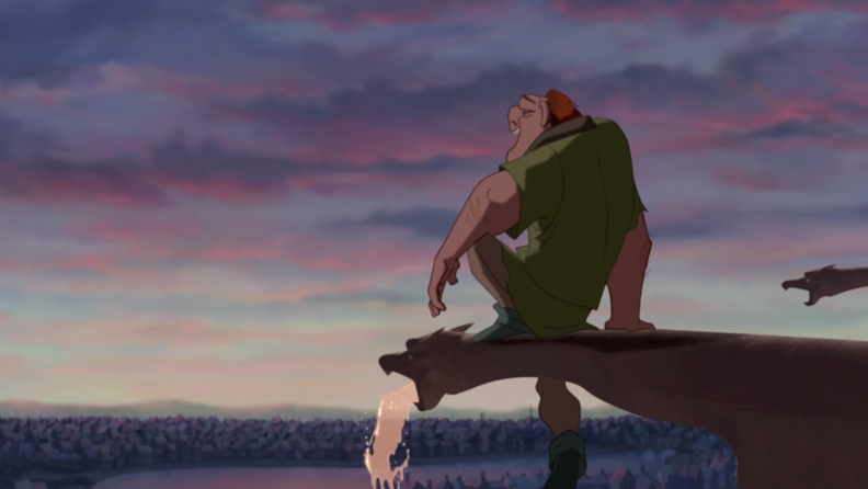 A still from 'The Hunchback of Notre Dame' featuring Quasimodo sitting on a gargoyle looking out over Paris.