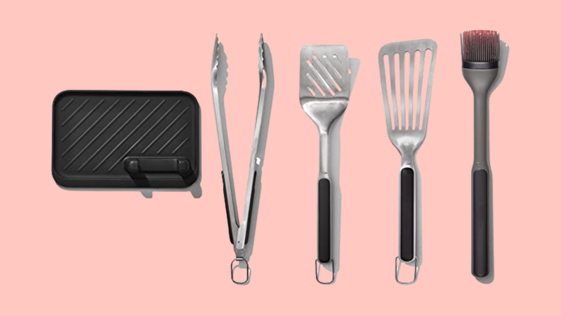 OXO grill accessories set with mat, thongs, spatulas, and basting brush on a pink background.