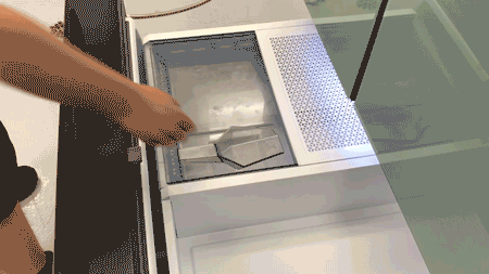 A person shown scooping ice from the Samsung freezer's dual ice buckets into a cup using scoop.