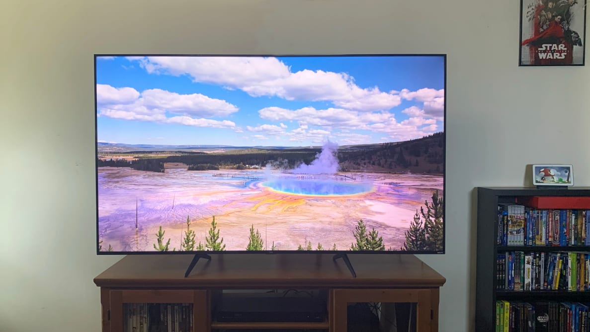 The TCL 5-Series displaying an image of Morning Glory hot spring while sitting on a wooden credenza.