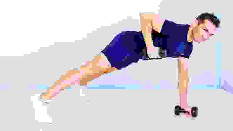 A personal trainer exercises with dumbbells in a push-up position.