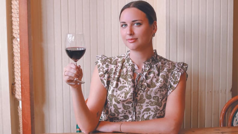 Photo of Marissa Mullen holding a glass of red wine.