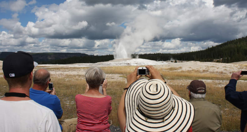Tourists at Yellowstone's Old Faithful geyser line up to grab the same shot. [Credit: Flickr user