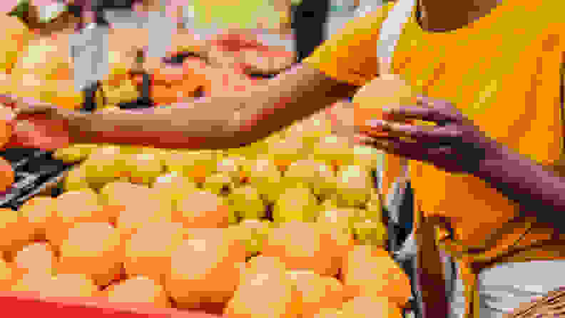 African American woman wearing a protective mask while buying groceries at the market