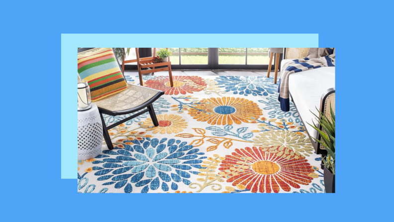 A floral print rug on a patio against a blue background.