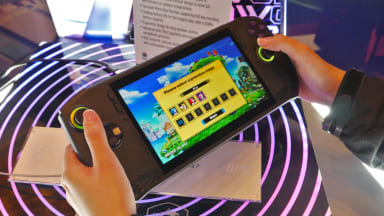 Person uses both hands to hold onto a portable gaming handheld device.