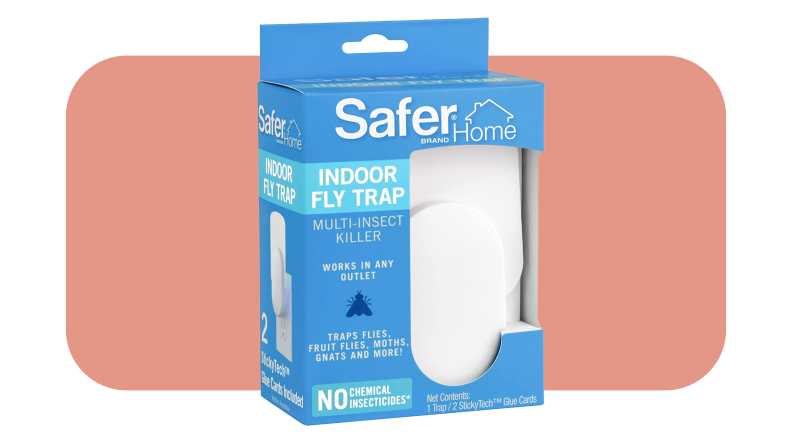 Product shot of the Safer Home Plug-in Fly Trap inside of blue box packaging in front of pink background.