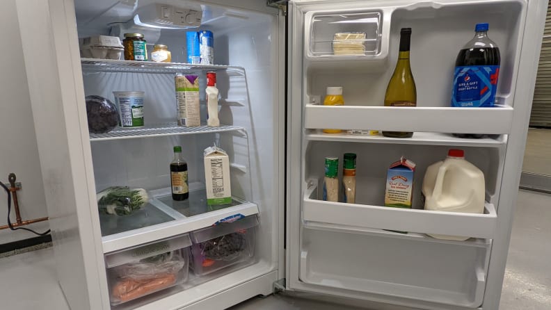 A close-up of the interior of the fridge, sitting next to other fridges in our testing lab. The door is open, revealing a fully-stocked interior and door bins.