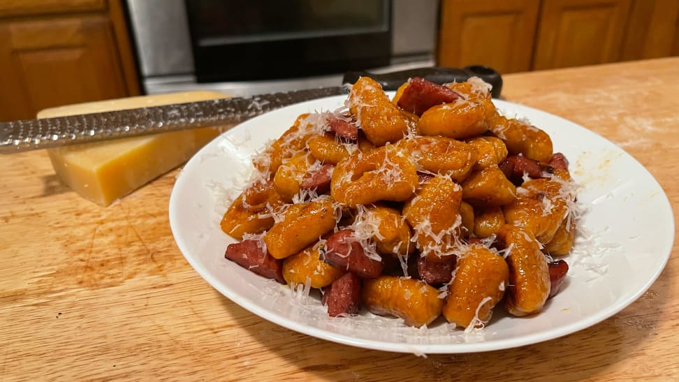 Butternut squash gnocchi on a plate with fresh parmesan cheese.