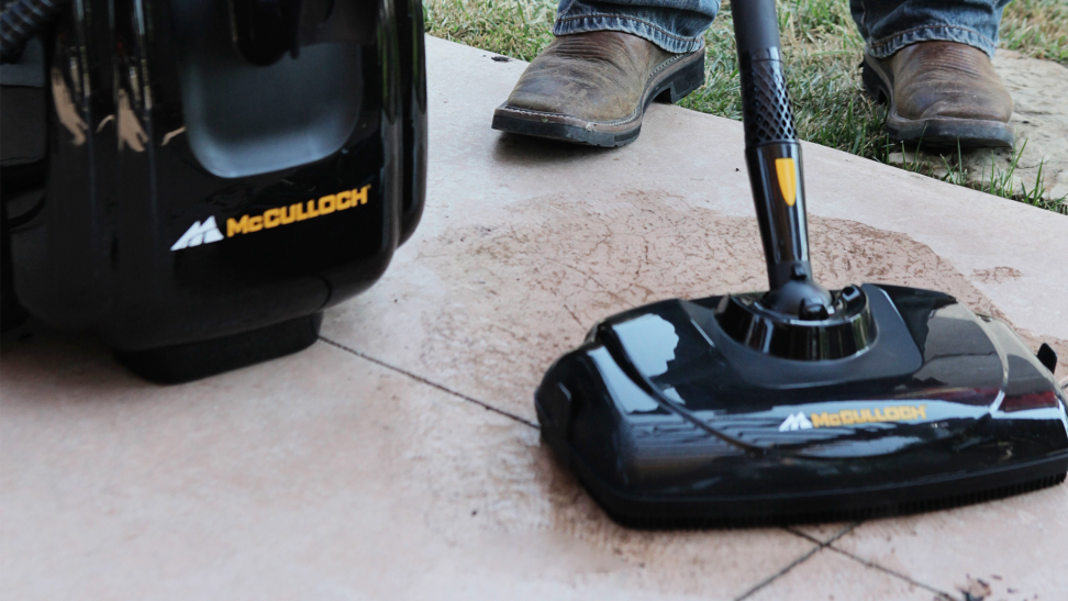 A model demonstrates the usefulness of a McCulloch steam cleaner on outdoor tile.