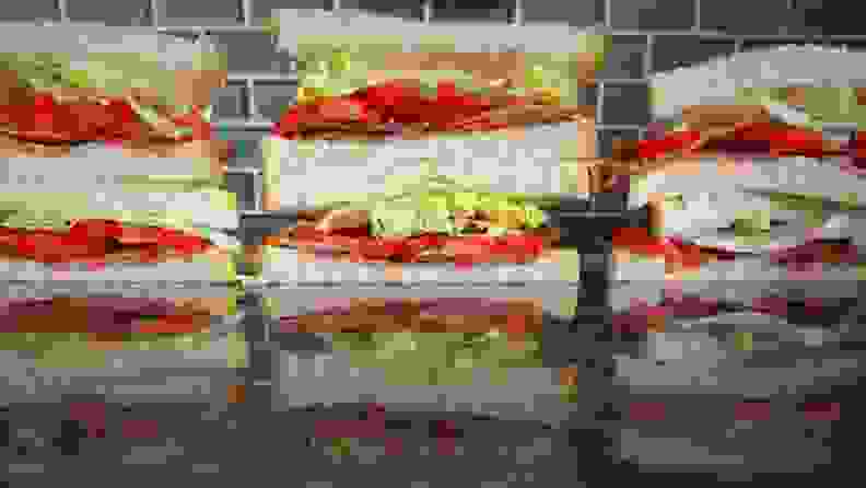 Three BLT sandwiches cut in half and stacked in piles of two, forming three even stacks.
