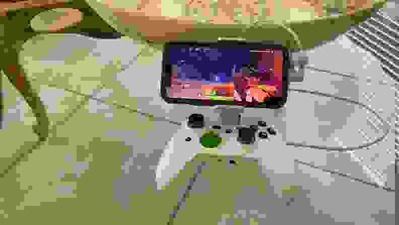 The RiotPWRXbox Cloud Gaming Controller with an iPhone mounted in its dock.