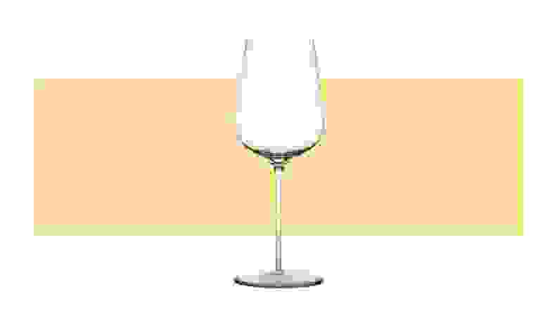 A single white wine glass on a yellow background.