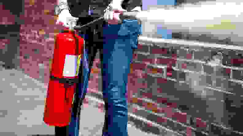 Person using a fire extinguisher outside
