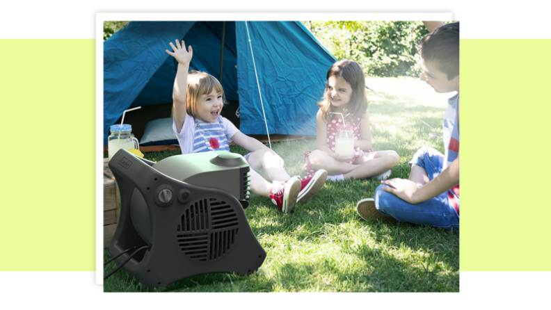 Children sitting on grass outdoors next to tent.