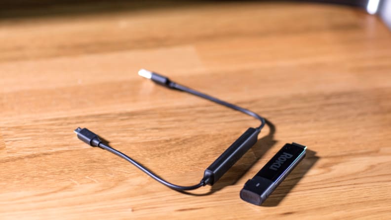 The Roku Streaming Stick+ and remote on a coffee table.