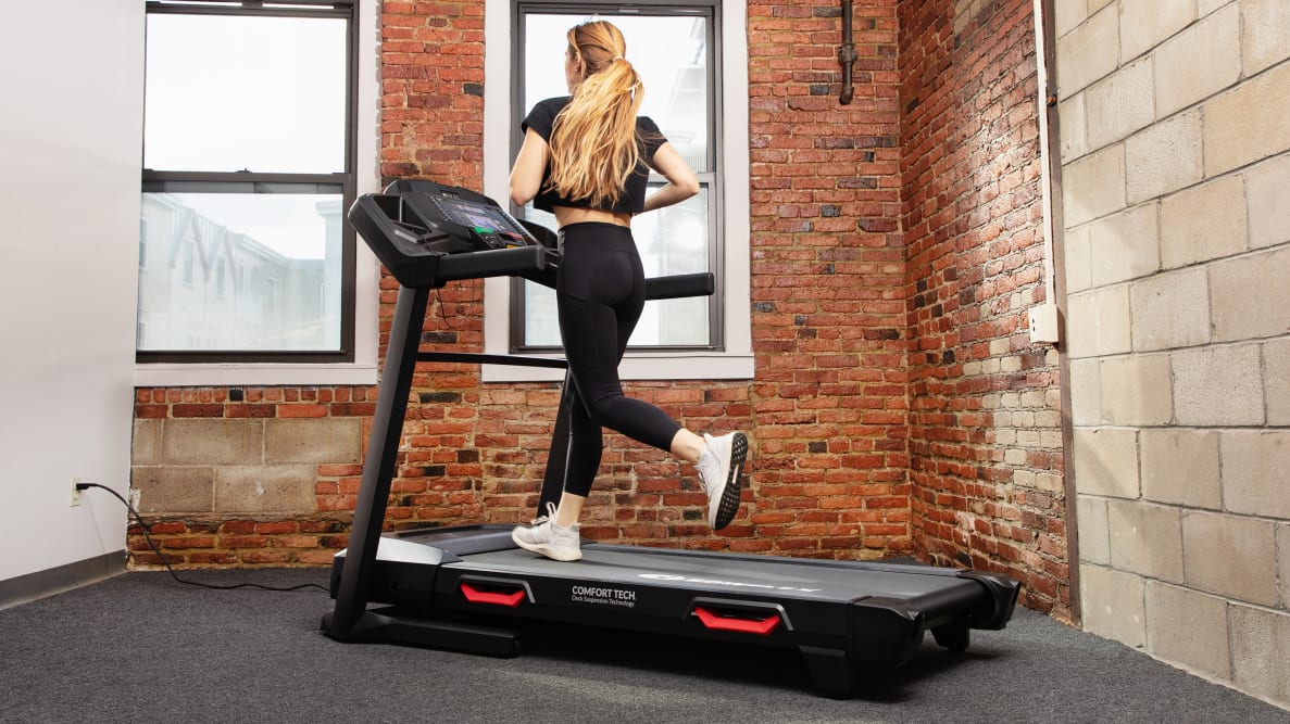 A woman runs on a Bowflex BXT8J treadmill.