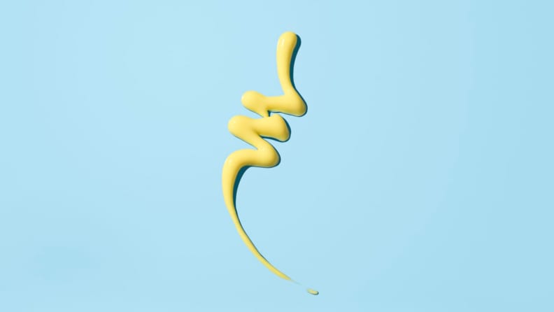 A yellow lotion-like squiggle of formula on a light blue background.