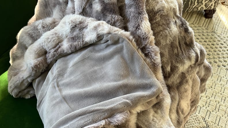 A faux fur blanket flipped so you can see its fleece underside