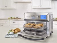 A Cuisinart Toaster Oven is being used on a kitchen table.