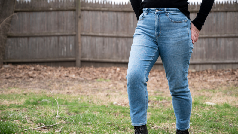 Girl wearing American Eagle jeans walks through the yard.