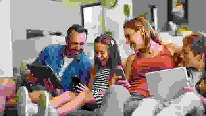 An excited family playing with their phones.