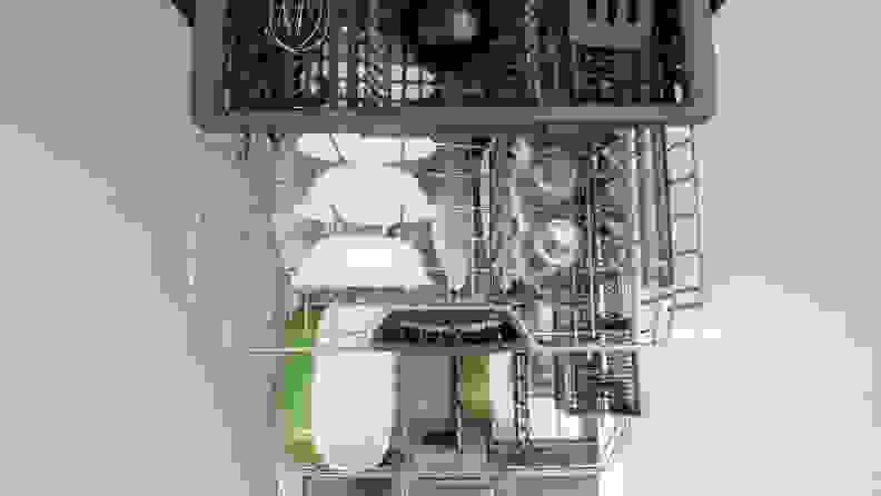 A top-down shot of the Bosch 500 Series SHPM65Z55N dishwasher, its door open and all three of its racks pulled out in a cascading fashion. Each rack is stocked with dishes.