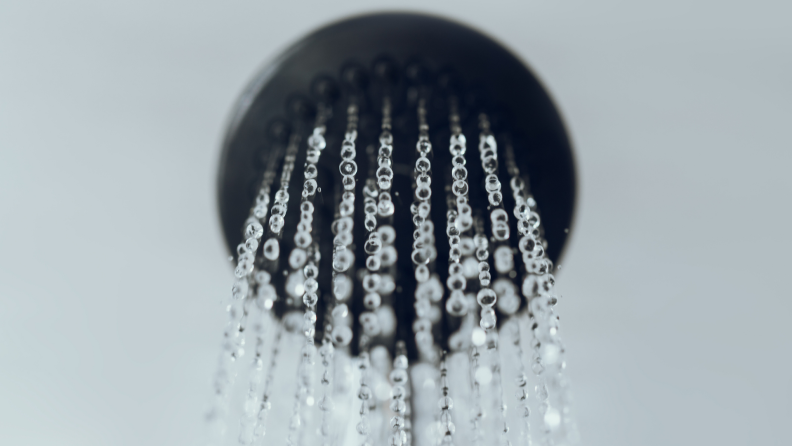 A running shower head in a bathroom.