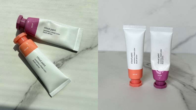 Two tubes of Glossier Cloud Paint in orange and purple shades against a marble-textured background.