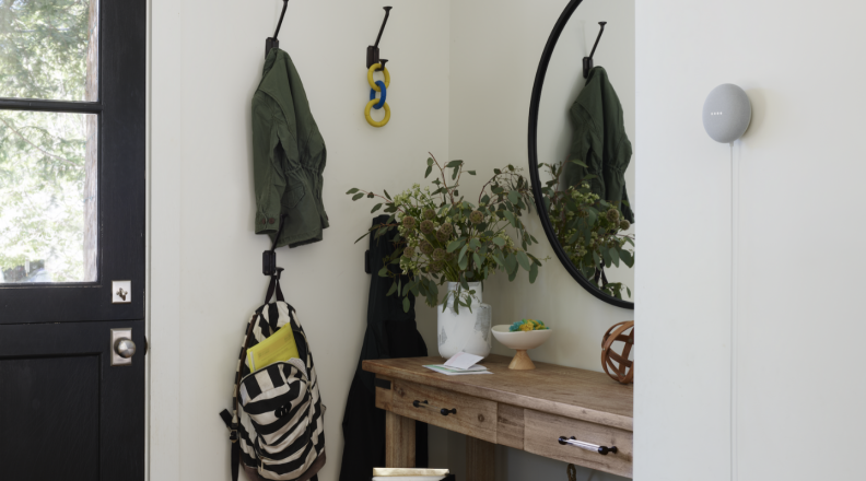 A Google Nest Mini hangs on the wall.